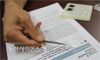 연구팀이 핀셋으로 이번에 개발한 광안개 메타 필름을 보이고 있다. - 신선미 기자, vamie@donga.com 제공
